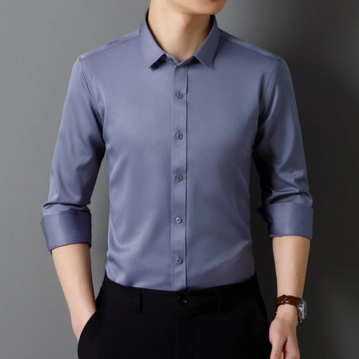 Person wearing a light blue dress shirt with rolled-up sleeves against a gray background