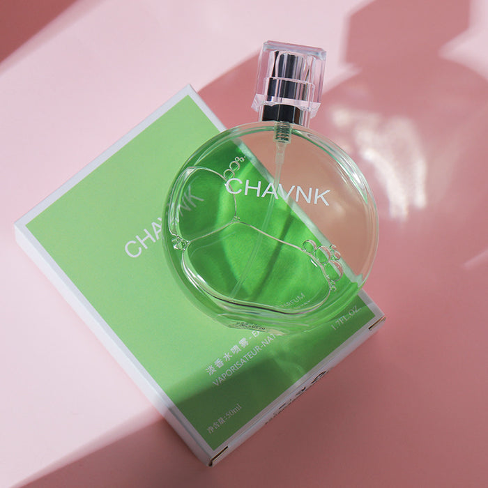 Clear perfume bottle with 'CHAVNK' branding on a pink surface