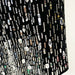 Close-up of a black fabric with various beads and sequins on a white background
