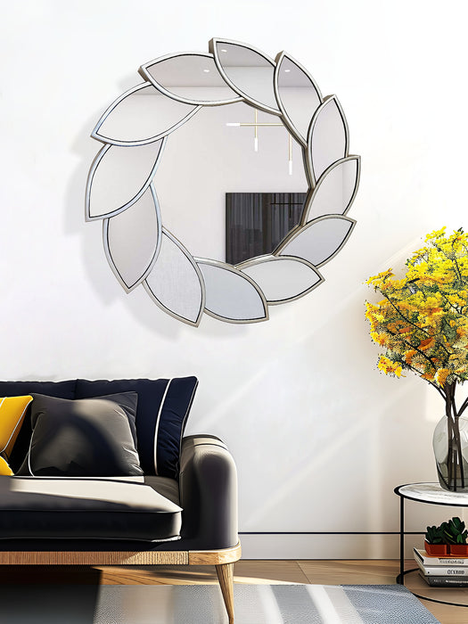 Decorative wall mirror with leaf-like design in a living room setting.