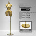 Gold female mannequin with stand on a gray background
