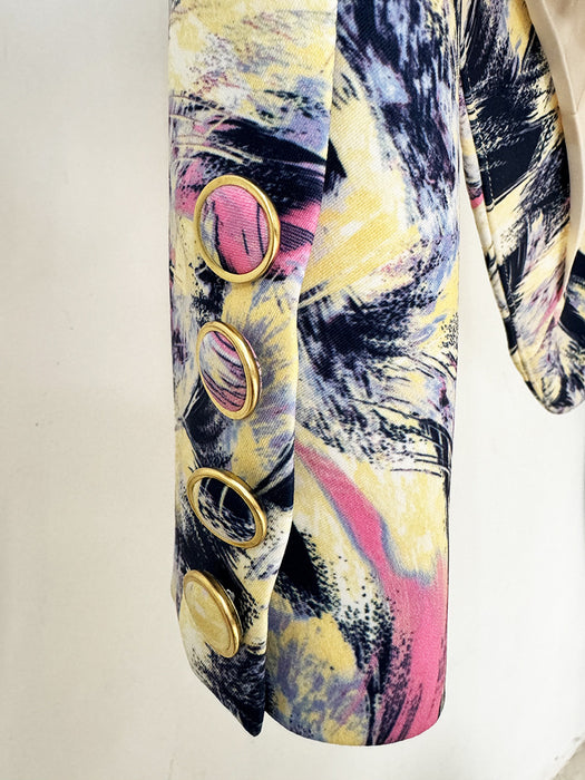 Colorful abstract patterned shoe with gold buttons on a white background