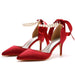 Red high-heeled shoes with pearl anklets on a white background