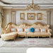 Luxurious living room with ornate beige sofa, decorative pillows, and framed artwork.