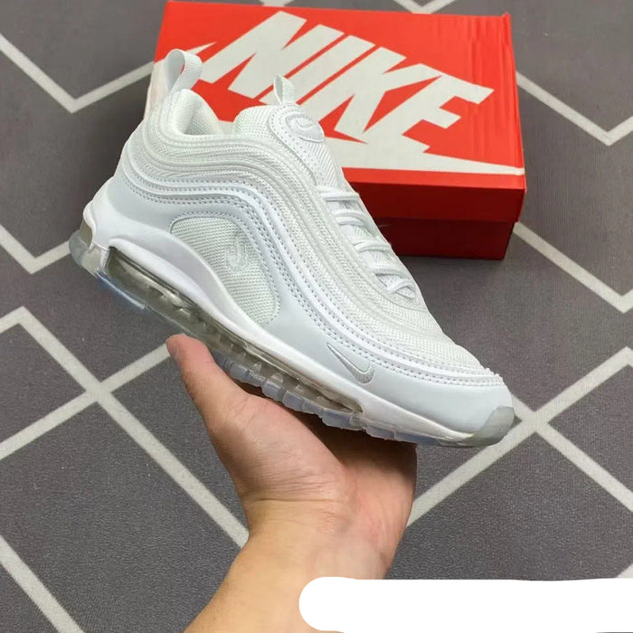 White sneaker held in a hand with a red Nike box in the background