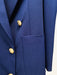 Close-up of a blue blazer with gold buttons on a white background