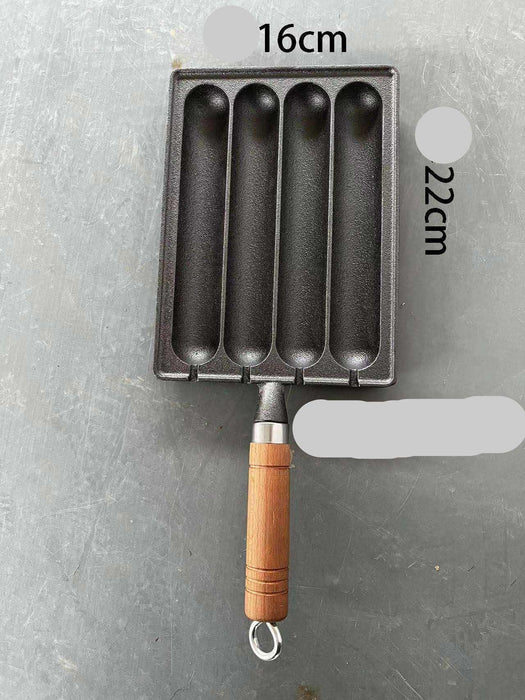 Black rectangular metal mold with wooden handle on a gray background