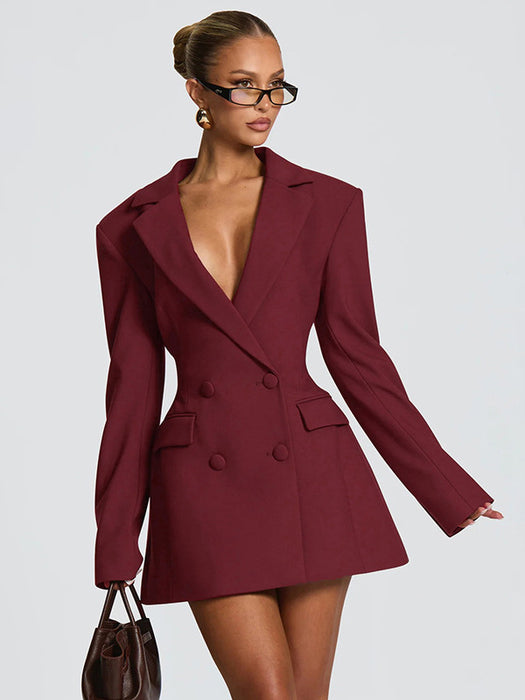 Woman wearing a burgundy blazer dress against a plain background