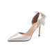 White high-heeled shoe with a large bow on a white background