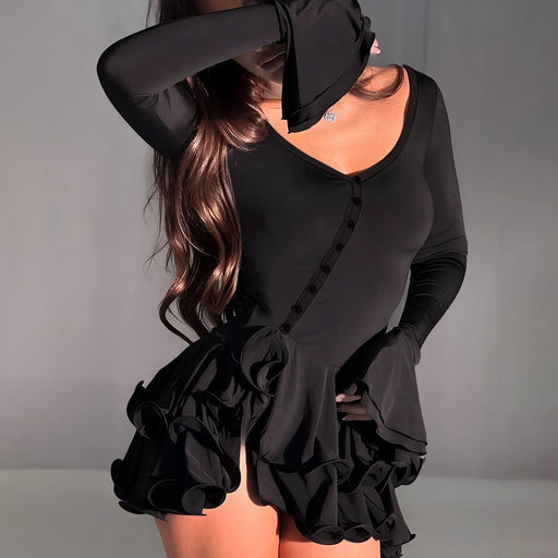 Black dress with ruffled details worn by a model against a neutral background