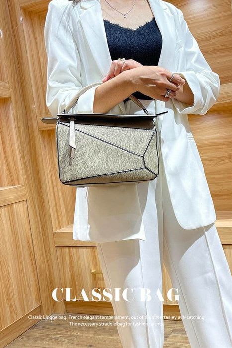 Person holding a beige handbag with a wooden panel background