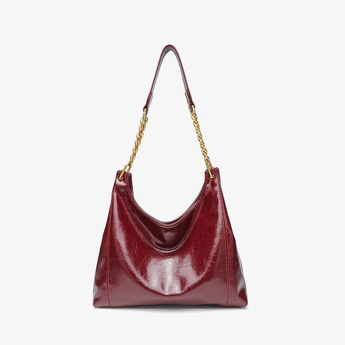 Red handbag with a gold chain strap on a white background
