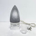 Silver steam iron with cord and plug on a white background