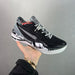 Black and white sneaker held in a hand against a gray background