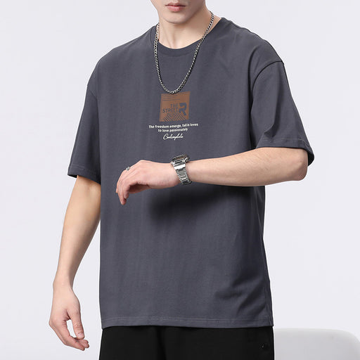 Person wearing a dark gray t-shirt with text and graphics on a plain background
