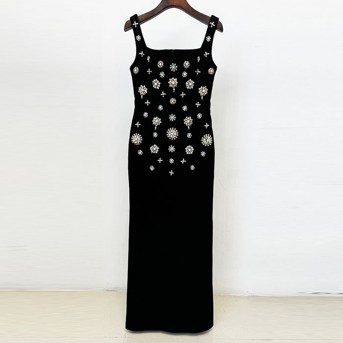 Black dress with floral embellishments on a wooden hanger against a white background
