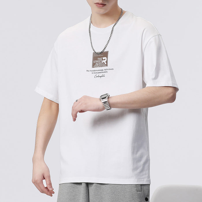 Person wearing a white t-shirt with a graphic design on a plain background