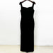 Black dress on a hanger against a white background