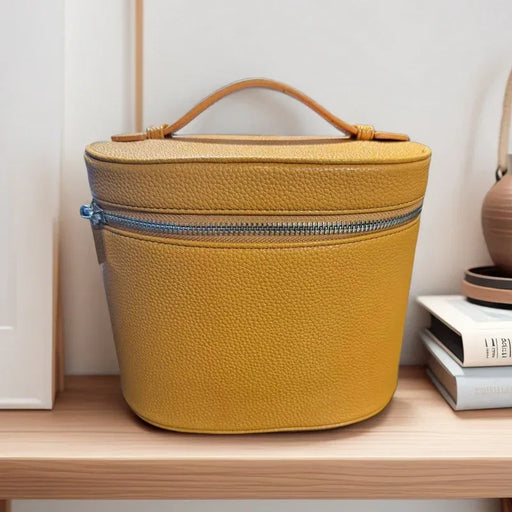 Yellow textured cosmetic bag on a wooden shelf with a white wall background