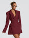Woman wearing a burgundy blazer dress against a plain background
