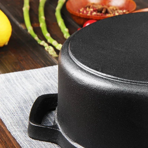 Black cast iron skillet on a wooden surface with vegetables in the background
