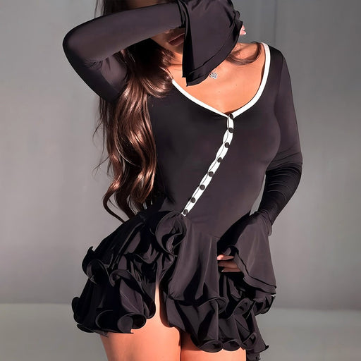 Black dress with ruffled details on a gray background