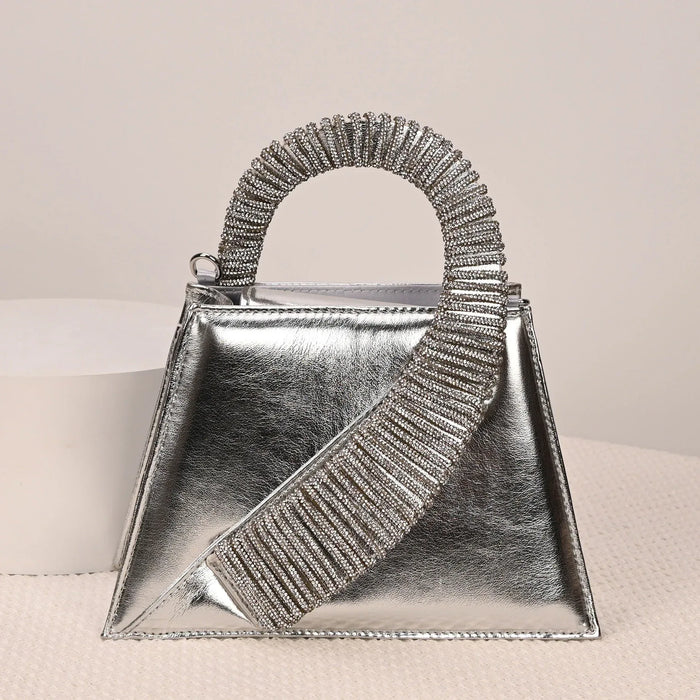 Silver handbag with decorative handle on a light background
