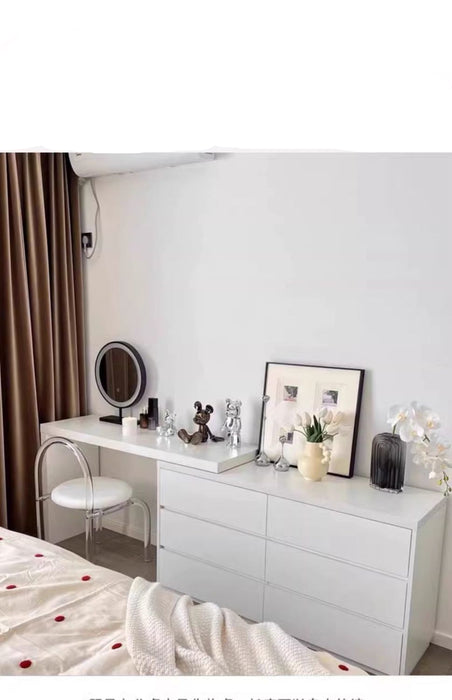 White dresser with mirror and decorative items in a bedroom setting
