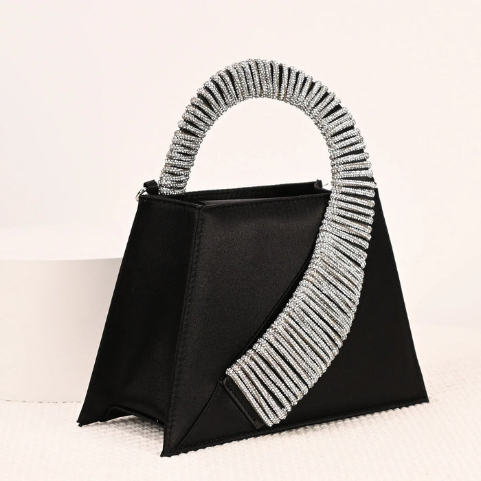 Black handbag with a decorative silver handle on a white background