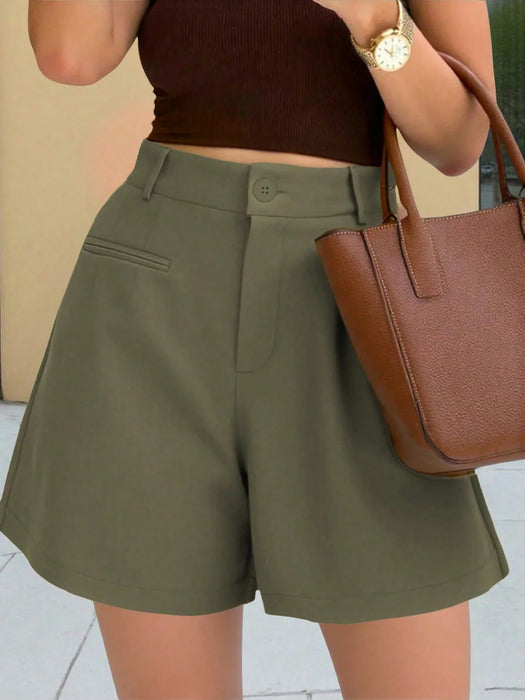 Person wearing olive green shorts and a brown top, holding a brown handbag.