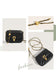 Black handbag with gold chain and clasp on a light background
