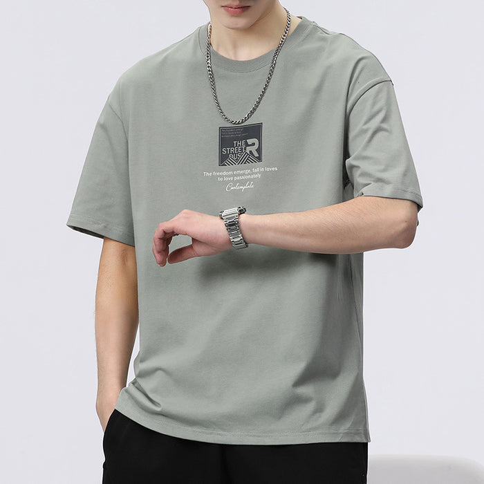 Person wearing a gray t-shirt with a logo and text on a plain background