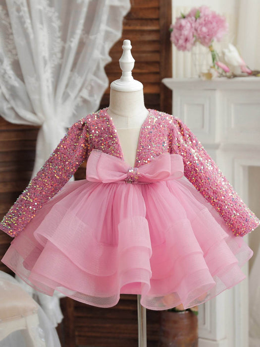 Pink sequin dress with a bow on a mannequin against a neutral background