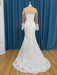 White lace wedding dress on a mannequin against a blue curtain background