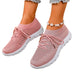Pink sneakers worn on feet with a white background