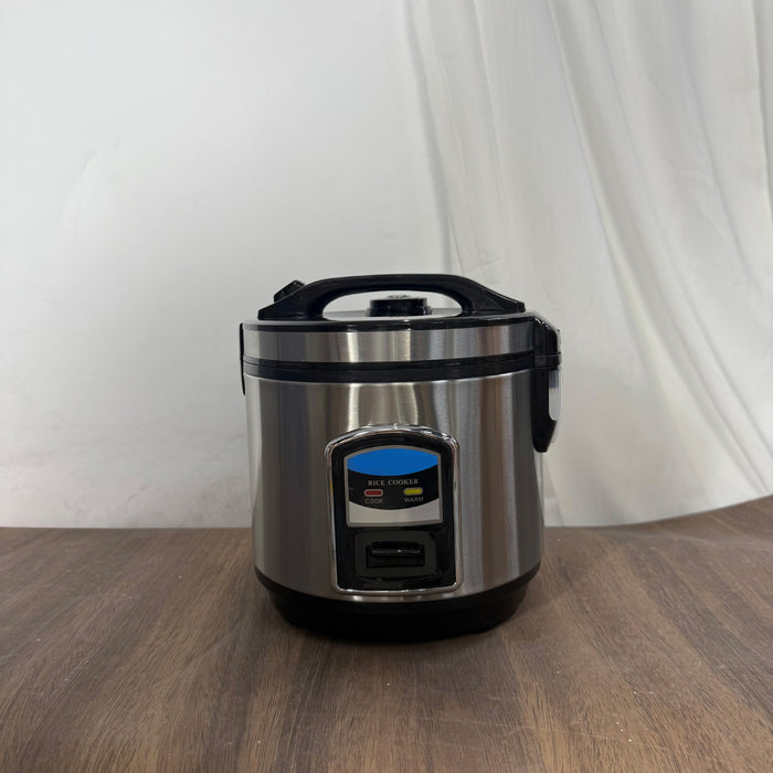 Stainless steel rice cooker on a wooden surface with a white curtain background