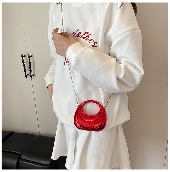 Person wearing a white sweatshirt with red text, holding a red handbag.