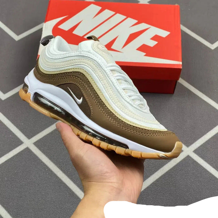 Brown and white sneaker held in hand with red Nike box in background