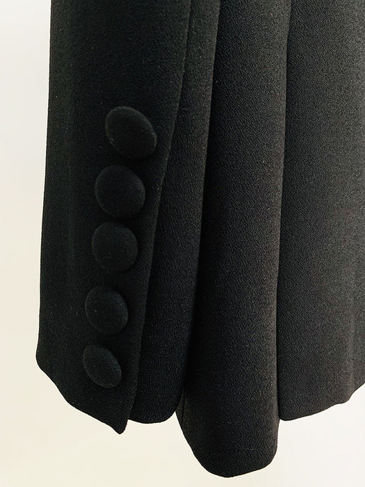 Close-up of a black coat with button details on a light background