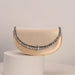 Beige handbag with decorative chain on a beige background