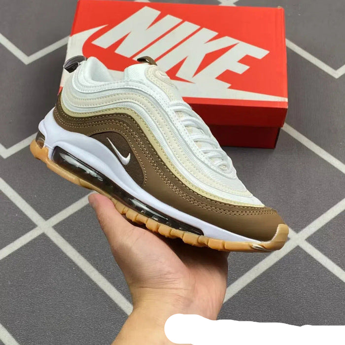 Brown and white sneaker held in hand with red Nike box in background
