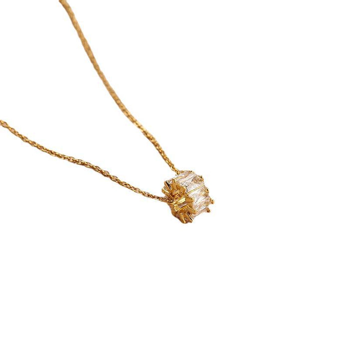 A gold chain necklace with a textured, rough-cut clear gemstone pendant, shown against a plain white background.