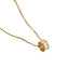A gold chain necklace with a textured, rough-cut clear gemstone pendant, shown against a plain white background.