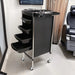 Black rolling cart with multiple drawers in a salon setting
