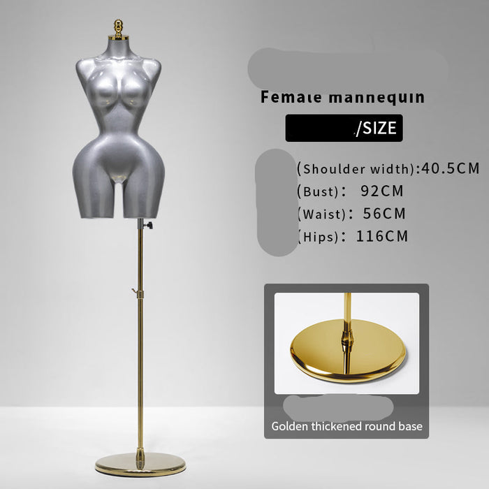 Silver female mannequin with gold base on a gray background