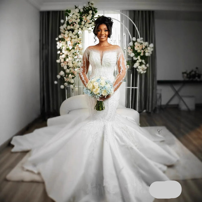 Bride in a white wedding dress holding a bouquet in a decorated room.