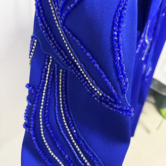 Close-up of a blue garment with intricate beadwork on a white background
