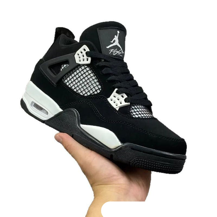 Black and white sneaker held in a hand against a white background