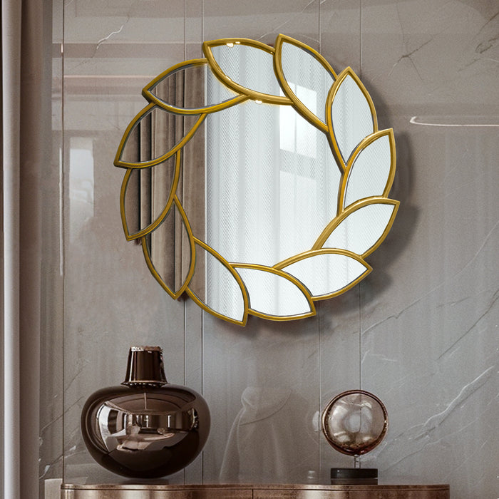 Decorative wall mirror with gold leaf design on a marble wall
