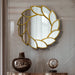 Decorative wall mirror with gold leaf design on a marble wall